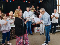 Beim Sommerfest der Lebenshilfe wird gemeinsam mit Besuchern aus Kendal gefeiert. Karina Olschewski überreicht Marco Reinking von der Lebenshilfe Rinteln ein Wimmelbild zum 20 jährigen Partnerschaftsjubiläum