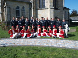 Vor der kath. Kirche St. Sturmius in Rinteln: Die Majoretten-Tanzgruppe und die Blaskapelle der Feuerwehr aus Slawno posieren mit dem Vorsittzenden des Rintelner Vereins für Städtepartnerschaften, Dietrich Lange (rechts), für ein Erinnerungsfoto. Foto: pr